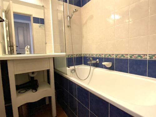 łazienka z wanną, umywalką i lustrem w obiekcie Appartement 2 Pièces avec Piscine et Parking - FR-1-504-663 w miejscowości Saint-Raphaël