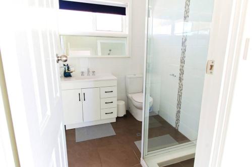 a bathroom with a toilet and a glass shower at The Parkview Retreat in Rockingham