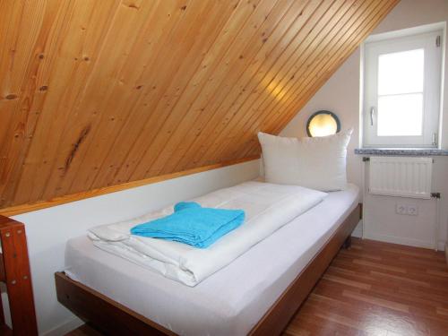 a bed in a room with a wooden ceiling at Apartment in Schultenbrook with garden in Metelsdorf