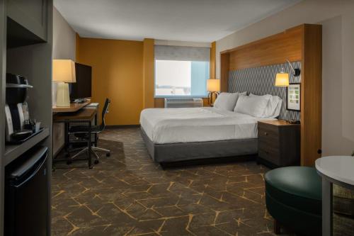 a hotel room with a bed and a desk at Holiday Inn Boston - Dedham Hotel & Conference Center by IHG in Dedham