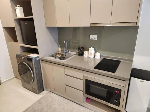 a kitchen with a sink and a washing machine at A cozy condotel in Bai Sau(1 bed and 1 sofa bed) in Vung Tau