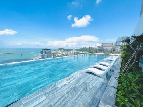 a swimming pool on top of a building with the ocean at A cozy condotel in Bai Sau(1 bed and 1 sofa bed) in Vung Tau