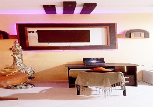 a room with a desk and a laptop on a wall at Welcome in Appartement marocain proche de la mer à Sidi Bouzid in Safi