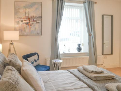 a bedroom with a bed and a window at Scotswood in Amble