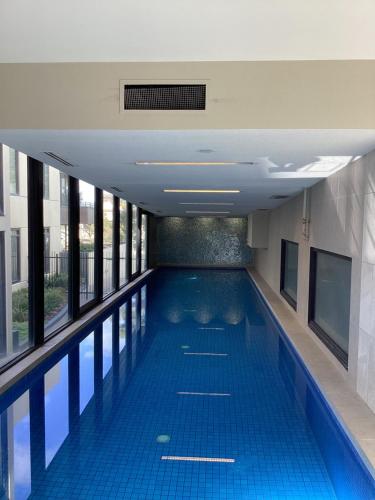 an empty swimming pool in a building with windows at In the Heart of Port Melbourne in Melbourne