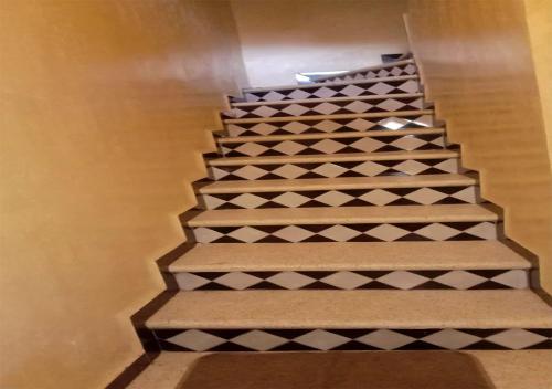 a set of stairs with black and white tiles at Welcome in Appartement marocain proche de la mer à Sidi Bouzid in Safi