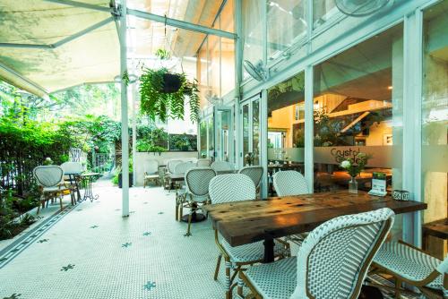 an outdoor patio with a wooden table and chairs at 6號花園別墅酒店 Shenzhen No'6 Garden Villa --French Window with garden view,Close to Sea World &Shekou Ferry Port &K11 Ecoast &Subway Nearby ,Offer Western food and coffee &English speaking with tour services in Shenzhen