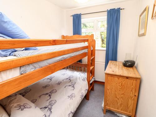 a bedroom with two bunk beds and a table at Hunter Cottage in Haltwhistle