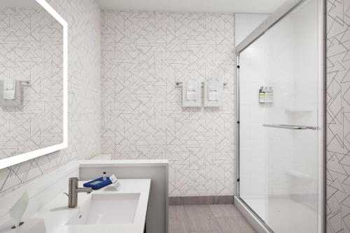 a white bathroom with a shower and a sink at Holiday Inn Express - Starke, an IHG Hotel in Starke