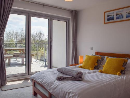 a bedroom with a bed and a sliding glass door at Muntjac Lodge in Somerford Keynes