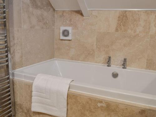 a bathroom with a bath tub with a towel on it at Muntjac Lodge in Somerford Keynes
