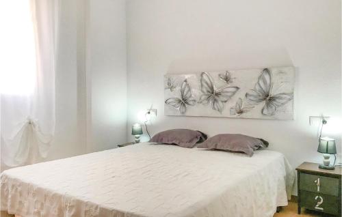 Los UrrutiasにあるCozy Home In Cartagena With Kitchenetteのベッドルーム1室(蝶2羽の壁に設置されたベッド1台付)