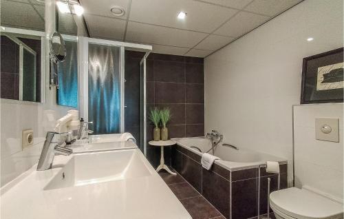 a bathroom with a tub and a sink and a toilet at Beach Front Apartment In Cadzand-bad With Kitchen in Cadzand-Bad