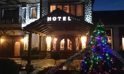 Un árbol de Navidad delante de un hotel por la noche en Khan Lankaran Hotel, en Lankaran