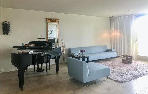 ein Wohnzimmer mit einem Klavier und einer blauen Couch in der Unterkunft Villa Van Staalduinen in Bergen aan Zee
