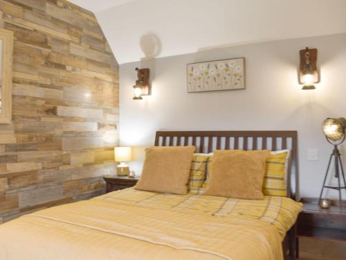 1 dormitorio con 1 cama con pared de madera en Taigh Violet Rose, en Gramisdale