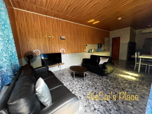sala de estar con sofá de cuero y mesa en KeCai’s Place en Digos