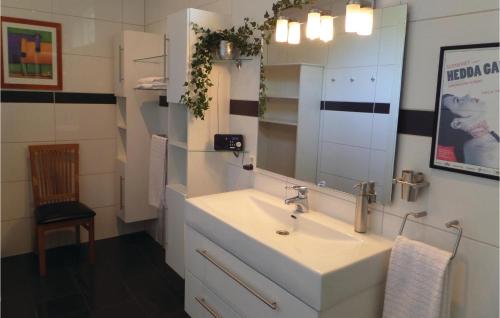 a bathroom with a sink and a mirror and a chair at Gorgeous Home In Sveio With Kitchen in Sveio