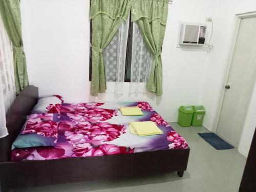 a bedroom with a bed with flowers on it at RGR CAMIGUIN TRAVEL TOUR SERVICES AND PENSION HOUSE in Mambajao