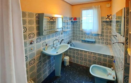a bathroom with a sink and a bath tub at 2 Bedroom Lovely Home In Plouhinec in Plouhinec