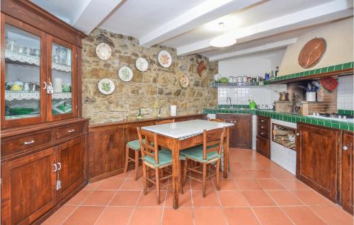 a kitchen with wooden cabinets and a table and chairs at 3 Bedroom Lovely Apartment In Nespolo in Nespolo