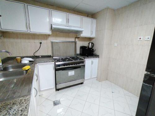 a small kitchen with a stove and a sink at Luxury 3 BHK family vacation home in Dubai