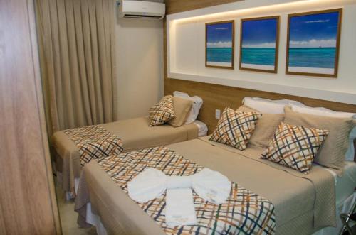 two beds in a hotel room with the ocean at FLAT PONTA NEGRA BEACH-Natal in Natal