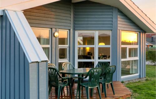 a screened in porch with a table and chairs at Friedrichskoog-Strandpark 15 in Friedrichskoog