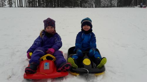 two children are sitting in the snow on skis at Gasthof zum Österntor in Medebach
