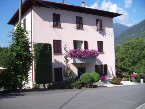 Un grand bâtiment blanc avec des fleurs sur les fenêtres dans l'établissement La casa rosa, à Sernio