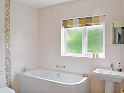 a white bathroom with a tub and a sink at Carr House in Cayton