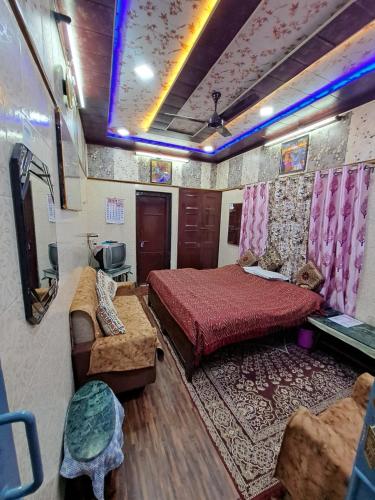 a bedroom with a bed and a couch in a room at Jagan Hotel & Restaurant in Dhaulpur