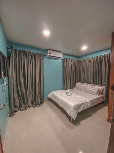 a bedroom with a bed and a window with curtains at Al-Mughni Homestay in Pasir Gudang