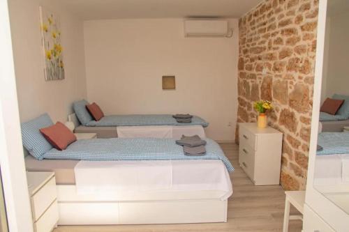 1 dormitorio con 2 camas y pared de ladrillo en Villa Villa Karaga - with private pool en Ljubotic