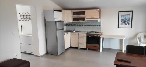 eine kleine Küche mit einem Kühlschrank und einem Tisch in der Unterkunft Apartments Dragi - with pool in Nin