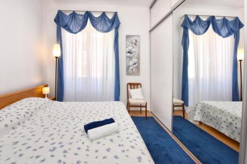 1 Schlafzimmer mit 2 Betten und blauen Vorhängen in der Unterkunft Apartment Ariana - central & comfy in Poreč