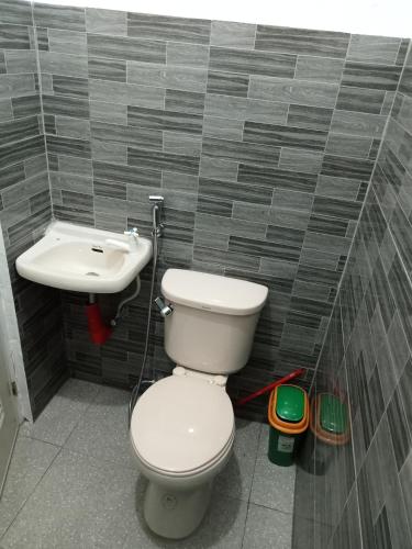 a bathroom with a toilet and a sink at RGR CAMIGUIN TRAVEL TOUR SERVICES AND PENSION HOUSE in Mambajao