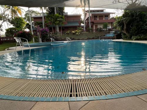 una grande piscina blu con sedie di Honlim villa homestay a Port Dickson
