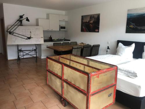 Zimmer mit 2 Betten, einem Tisch und einer Küche in der Unterkunft NringRooms Exit-Breidscheid in Adenau