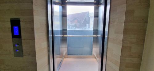 a glass elevator in a building with a door at Zukiya Residences Baguio in Baguio