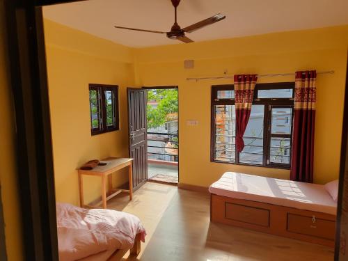 1 dormitorio con paredes amarillas, 1 cama y ventana en HOTEL FORESTWAY Hostel & Backpackers, en Pokhara