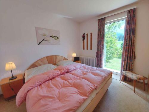 Apartment in Bad Mitterndorf - Steiermark 41509 في باد ميترندورف: غرفة نوم بسرير وردي ونافذة كبيرة