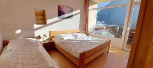 une chambre avec deux lits et une grande fenêtre dans l'établissement Apartment in Bad Mitterndorf - Steiermark 37021, à Bad Mitterndorf
