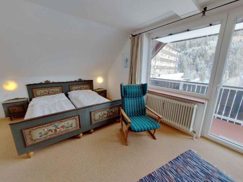 ein Schlafzimmer mit einem Bett, einem Stuhl und einem Fenster in der Unterkunft Apartments in Bad Mitterndorf - Steiermark 41123 in Bad Mitterndorf