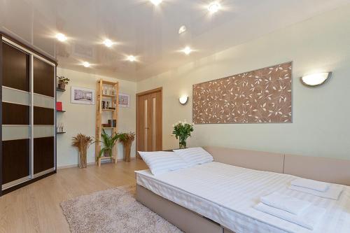 ein Schlafzimmer mit einem großen Bett mit weißer Bettwäsche in der Unterkunft Vip-kvartira Kuzmy Chornogo 4 in Minsk