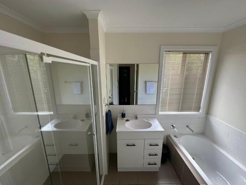 a bathroom with two sinks and a shower and a tub at CandE on Wheelton in Kingscote