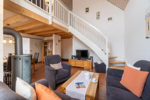 a living room with a fireplace and a staircase at Kapitänskoje in Greetsiel