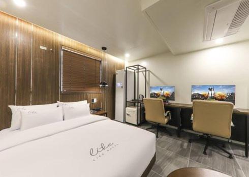 een slaapkamer met een bed, een bureau en stoelen bij Like Hotel in Gwangju