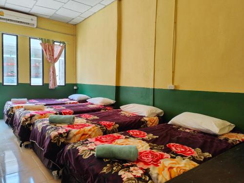 Una fila de camas en una habitación con flores. en 74 Guest House Haad Rin, en Haad Rin