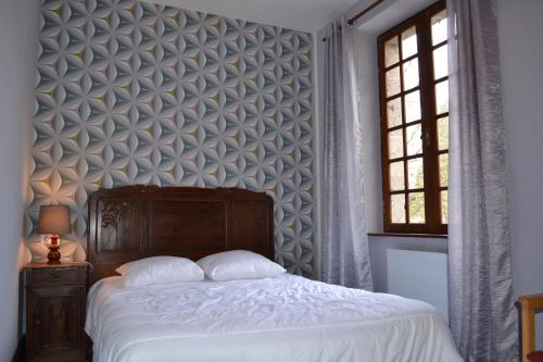 a bedroom with a large bed and a wall at Moulin de Saint Laurent in Saint-Laurent